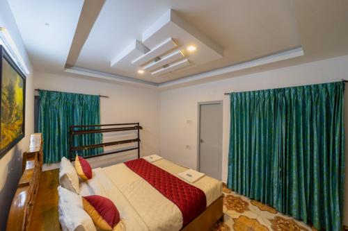 a bedroom with a large bed with green curtains at Fortune Retreats in Ooty