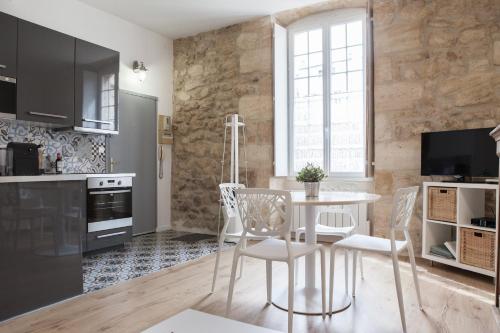 une cuisine et une salle à manger avec une table et des chaises dans l'établissement Augustins -Petit cocon calme et lumineux avec parking, à Bordeaux