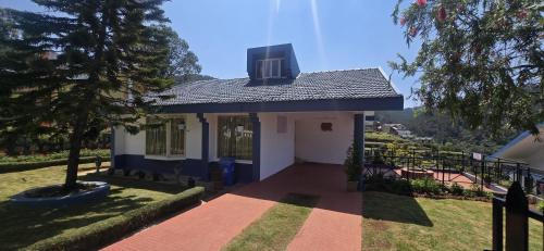 a small house with a blue roof at Fortune Retreats in Ooty