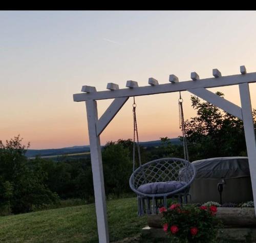 a swing on a hill with the sunset in the background at Kuća za odmor "Vila Marina" in Klokočevik