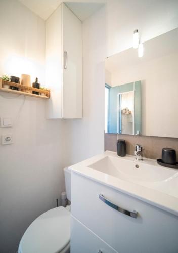 une salle de bain avec un lavabo blanc et des toilettes dans l'établissement Le Rivage du Nilautom, à Gruissan