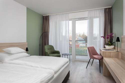 a hotel room with a bed and a window at Hunguest Hotel Flóra in Eger