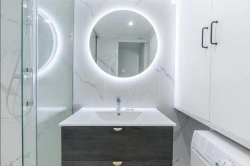 une salle de bain avec un lavabo et un miroir dans l'établissement Trail Fishmonger Cosy Apartment 4P, à Paris