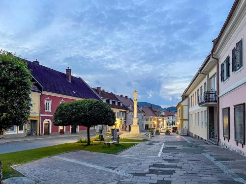 a cobblestone street in a town with a clock tower at Platzfaerberhaus in Obdach