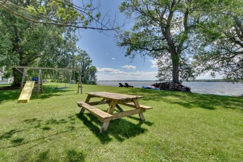 a picnic table in a park next to a playground at Lakefront Retreat with Shared Dock and Fire Pit! in Swanton