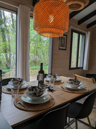 - une table à manger avec une bouteille de vin et des verres dans l'établissement Lodge Hérisson avec Spa privatif, à Biron