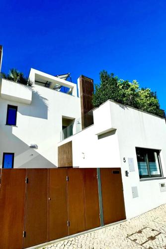 a white building with a brown garage at Casa ancora azul Fuseta in Fuzeta