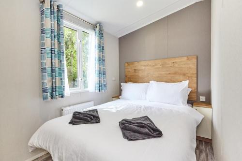 a bedroom with a white bed and a window at Campsie Glen Holiday Park in Glasgow