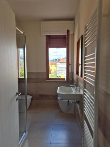a bathroom with a sink and a toilet and a window at Il brigidino in Lamporecchio