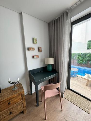 a desk with a lamp and a chair in a room at Casa ancora azul Fuseta in Fuzeta