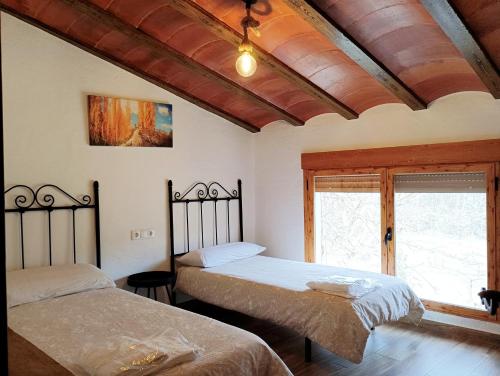 a bedroom with two beds and a window at Cortijo Ramon Petra in Nerpio
