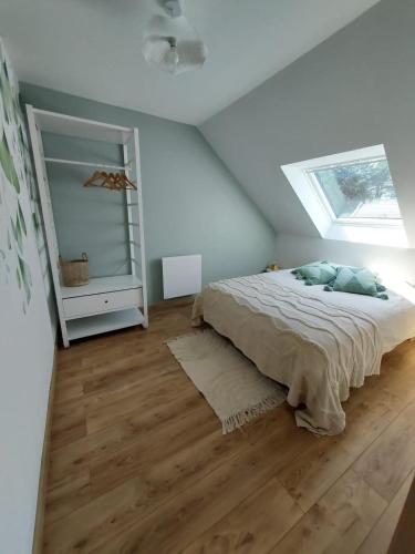 une chambre avec un lit et une lucarne dans l'établissement appartement proche plage avec jacuzzi, à Camiers