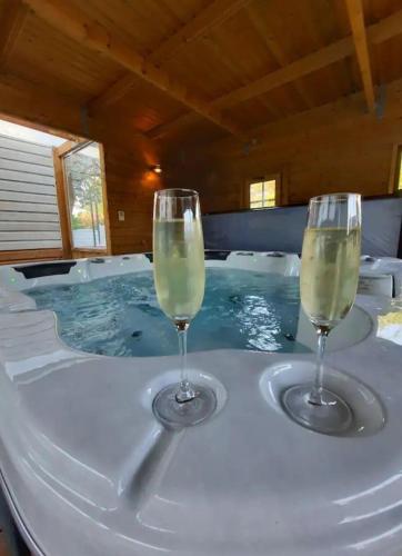 deux verres de vin assis sur une table dans un jacuzzi dans l'établissement appartement proche plage avec jacuzzi, à Camiers