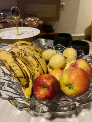 un piatto di banane e mele su un tavolo di شقه فندقيهPS4-حدايق الاهراماتPyramids a ‘Ezbet `Abd el-Ḥamîd