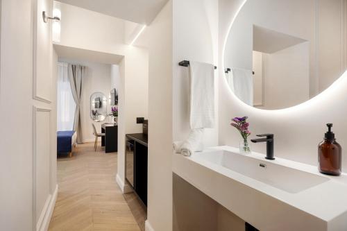 a white bathroom with a sink and a mirror at Sistina Boutique Guest House in Rome