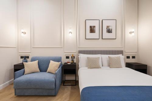a bedroom with a bed and a blue chair at Sistina Boutique Guest House in Rome
