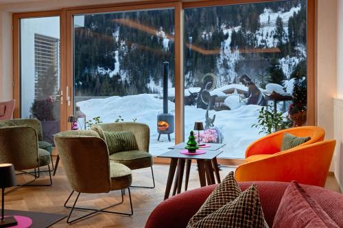 a living room with a view of a snow covered yard at Der Waldhof - Unique - A hidden gem in Sankt Anton am Arlberg
