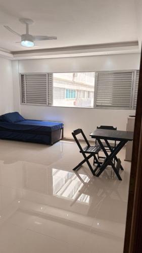 een kamer met een tafel en een bed en een tafel en stoel bij Apê da divisa in São Vicente