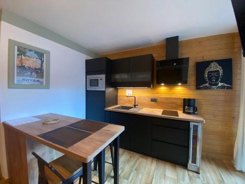 une cuisine avec une table et un comptoir dans l'établissement My 3 stars BEE HAPPY studio, à Brides-les-Bains