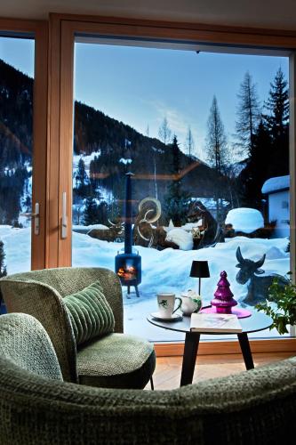 a living room with a view of a snow covered yard at Der Waldhof - Unique - A hidden gem in Sankt Anton am Arlberg