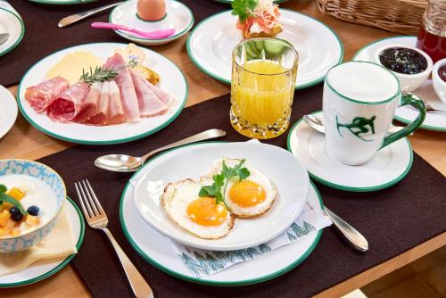 a table topped with plates of breakfast foods and drinks at Der Waldhof - Unique - A hidden gem in Sankt Anton am Arlberg