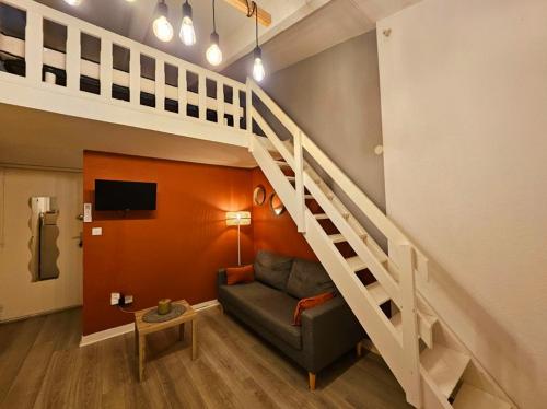 un salon avec un canapé et un escalier dans l'établissement Résidence Eureka-clim-parking-Wifi-piscine-Proche village natu, au Cap d'Agde