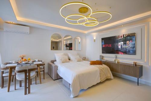 une chambre avec un lit, une table et un lustre dans l'établissement Luxe Azure Escape I Collection, à Juan-les-Pins