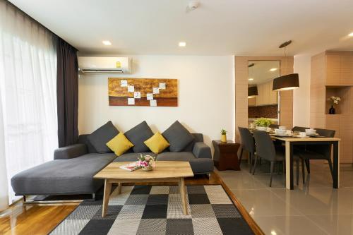 a living room with a couch and a table at Shine Aparthotels Sukhumvit Thonglor in Bangkok