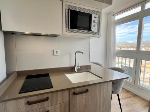 a kitchen with a sink and a microwave at Alta Vista! in Puerto de Mazarrón
