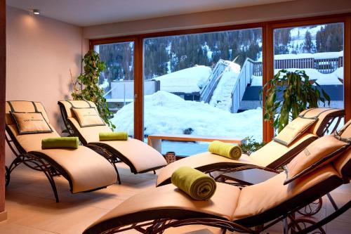 a group of chairs in a room with snow outside at Der Waldhof - Unique - A hidden gem in Sankt Anton am Arlberg