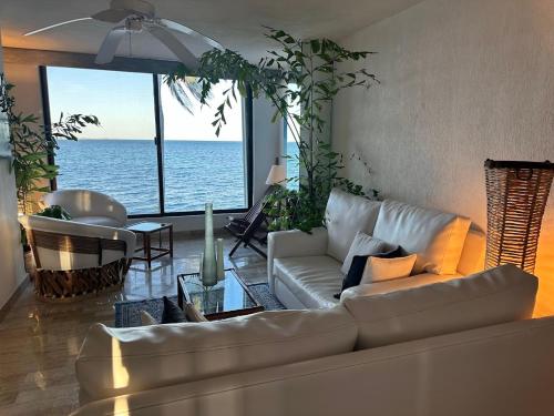a living room with a couch and a view of the ocean at Cancun condo en la playa de Puerto Juarez in Cancún