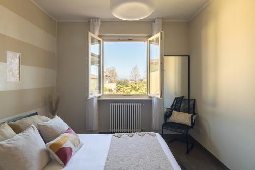 シルミオーネにあるMontecarlo Charme Apartmentのベッドと大きな窓のある寝室