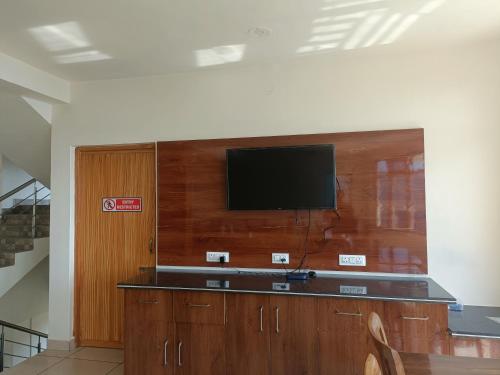 a flat screen tv on top of a wooden wall at The village lodge Dalhousie in Banikhet