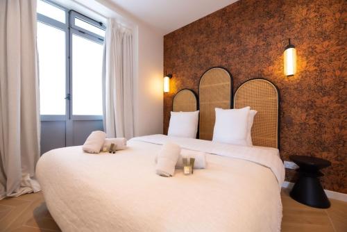 - une chambre avec un grand lit blanc et des oreillers blancs dans l'établissement 1 Cozy 1BR Exhibition Centre Porte de Versailles, à Paris