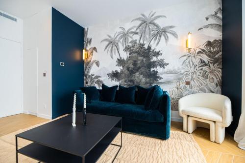 un salon avec un canapé bleu et une table dans l'établissement 1 Cozy 1BR Exhibition Centre Porte de Versailles, à Paris