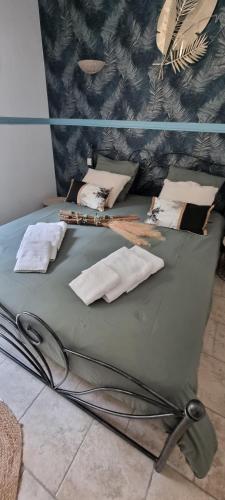 - un lit vert avec des oreillers dans l'établissement Villa Les jardins de Raiatea, à Sarlat-la-Canéda