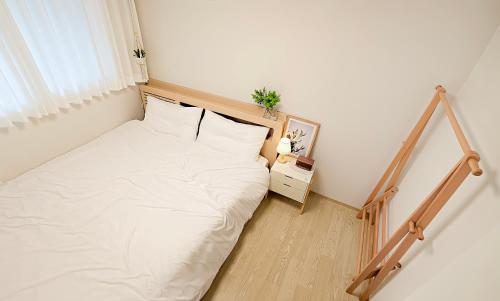 a small bedroom with a bed with white sheets at Gyeongju Florian Stay Stay Close Explore More in Gyeongju