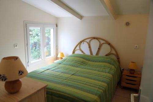 une chambre avec un lit vert et une fenêtre dans l'établissement Maison 6 personnes sur grand terrain 100 m plage - V0261, à Vias