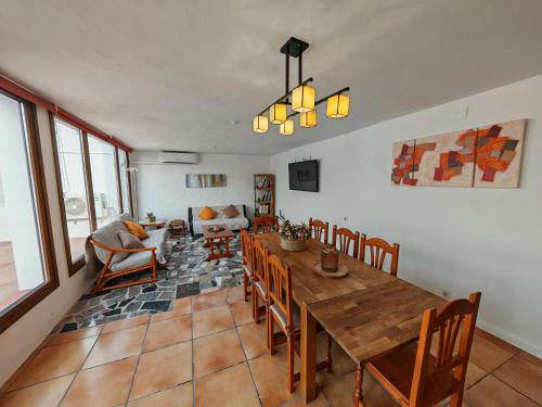 a living room with a wooden table and chairs at Ca la Consol in El Poblenou del Delta