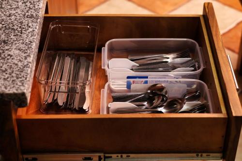 a wooden drawer with utensils in it at Ceiba Hostel in Fortuna