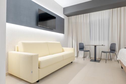 a living room with a white couch and a table at LHI Healthy Hotel Lecce in Lecce