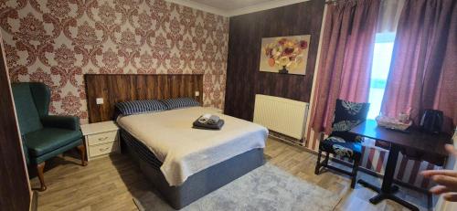 a bedroom with a bed and a green chair at Bright Apartments in Peterborough