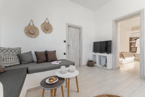 a living room with a couch and a tv at Touch Naxos Sunset in Galanado