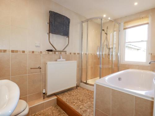 a bathroom with a tub and a toilet and a sink at 2 Bell Tower in Penzance