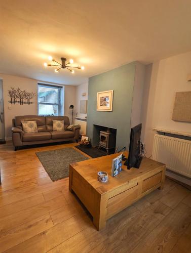 a living room with a couch and a coffee table at Relaxing Coastal Retreat for 2 Hot Tub Log Fire in Tywyn