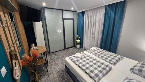 a bedroom with a bed and a table in a room at Pensjonat Lubianka in Starachowice