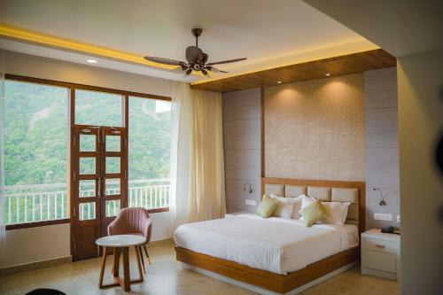 a bedroom with a bed and a large window at The TeaTree Munnar in Suryanelli