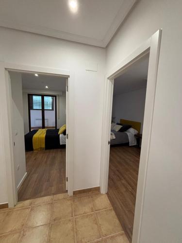 a room with two beds and a room with a hallway at Piso Carballal, Fantástico piso en pleno centro in Leiro