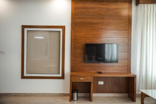 a living room with a television and a mirror at The TeaTree Munnar in Suryanelli