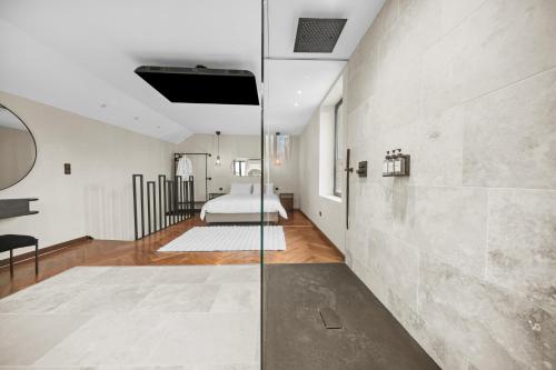 a room with a bed and a glass wall at Maison d'architecte avec Jacuzzi, Quartier Prémontrés in Pont-à-Mousson